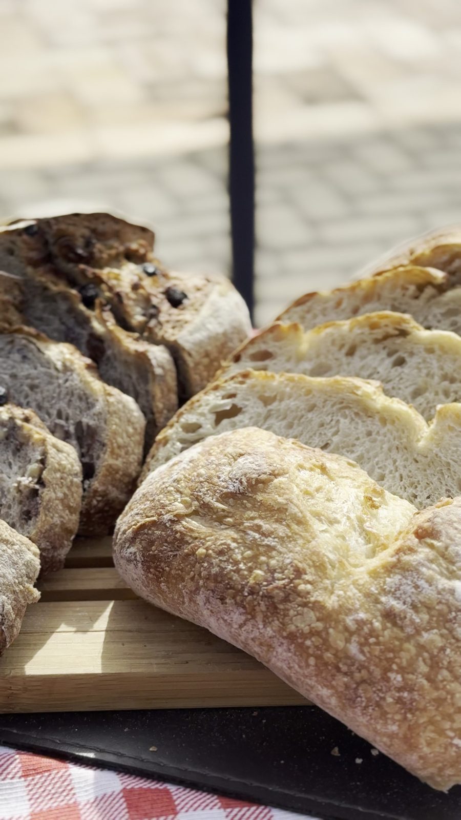 Pão de fermentação natural sendo fatiado, casca rústica — Recanto das Seriemas