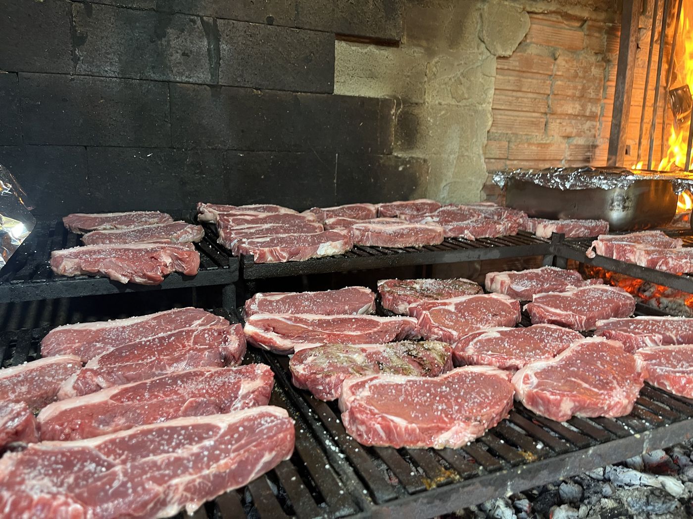 Parrilla de lenha em capacidade máxima durante evento de 81 pessoas — Recanto das Seriemas, abril/2026
