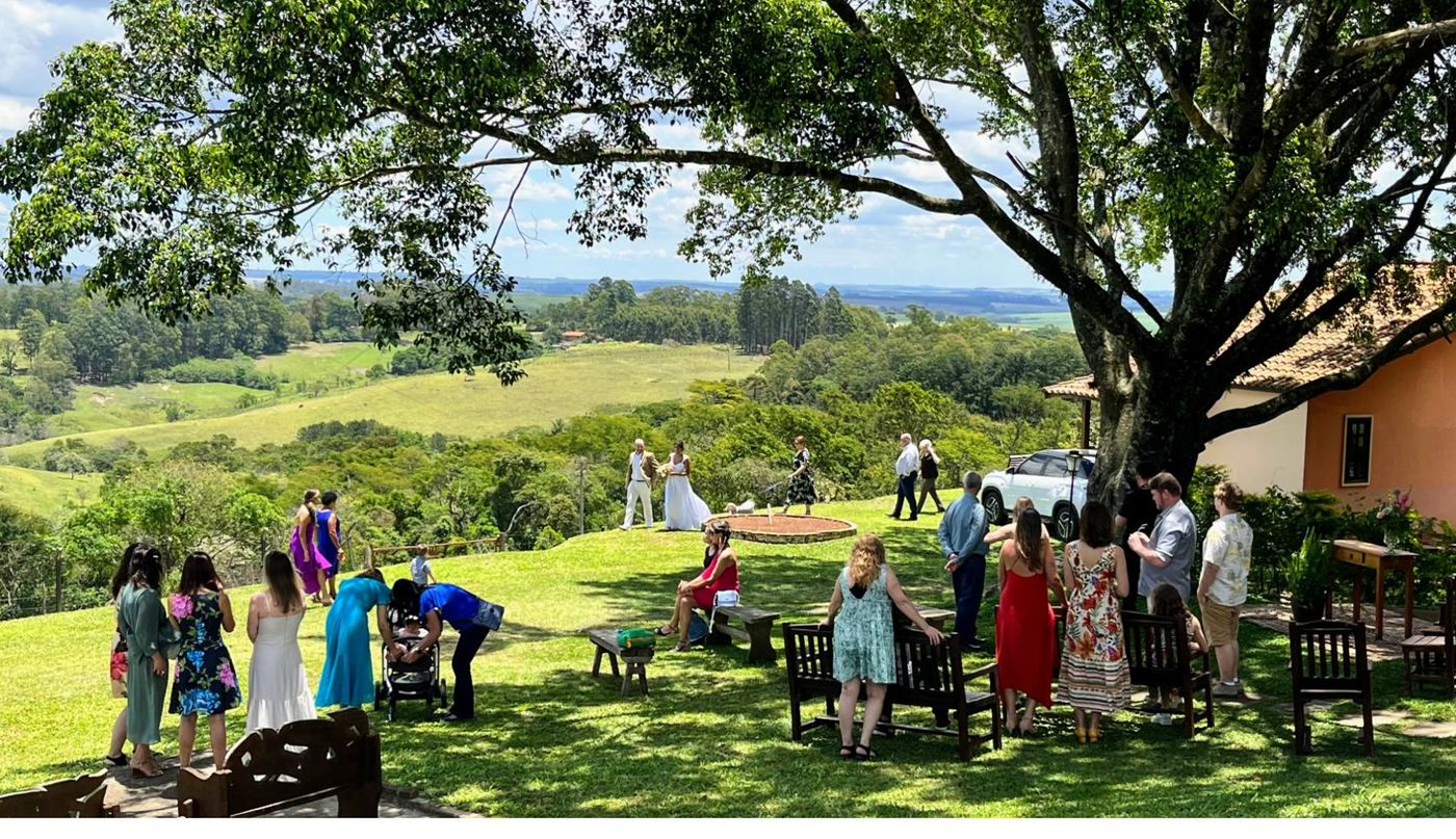 Convidados e noivos durante cerimônia de casamento sob a árvore com vista do vale — Recanto das Seriemas