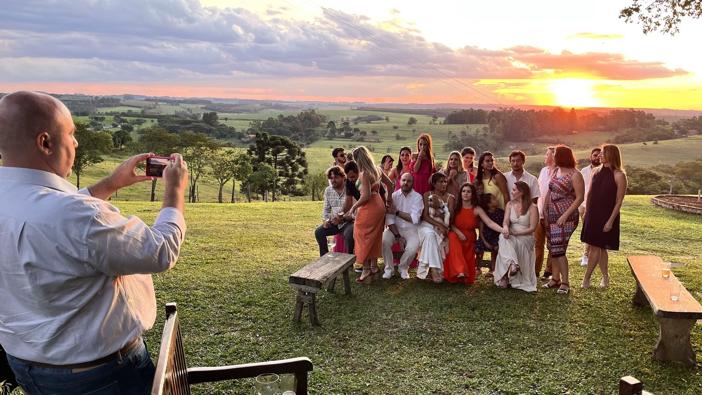 Grupo de convidados na sessão de fotos ao pôr do sol, com vista deslumbrante do vale ao fundo — Recanto das Seriemas