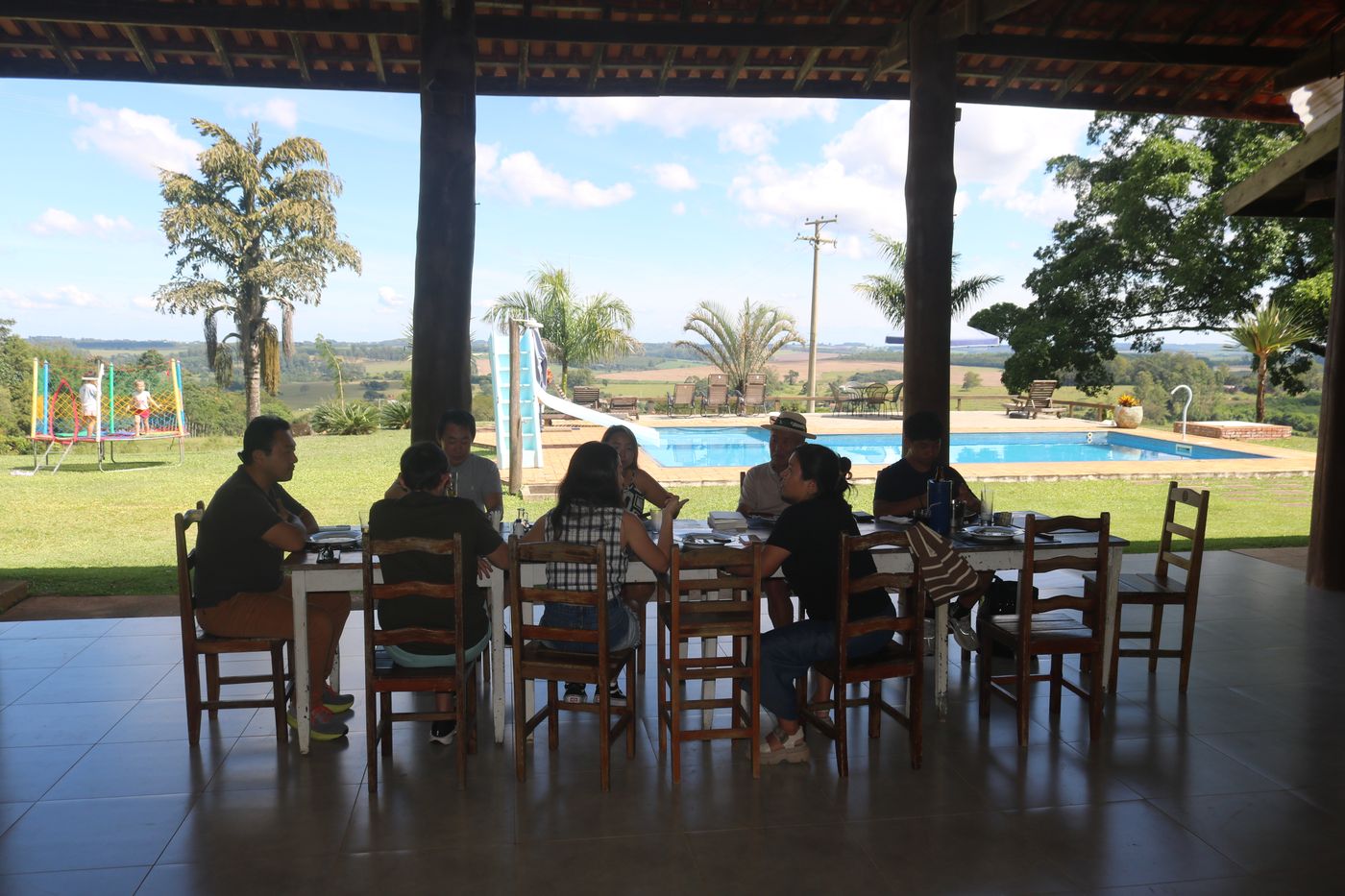 Mesa de almoço de domingo na varanda do restaurante com vista para piscina e vale — Seriemas Parrilla, Serra do Itaqueri
