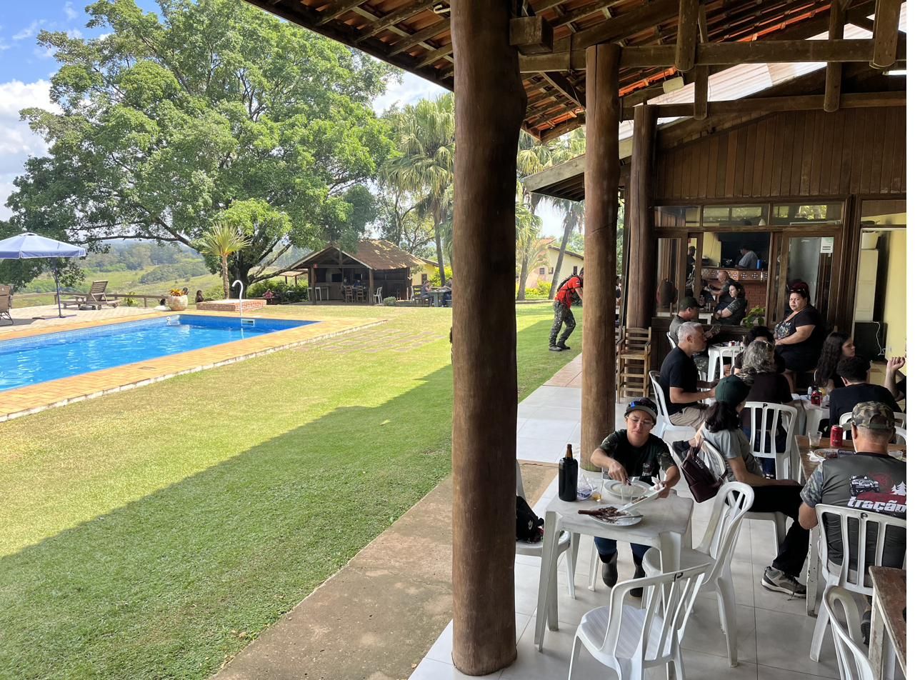 Restaurante operando em capacidade máxima durante evento, com piscina panorâmica ao lado — Recanto das Seriemas, abril/2026